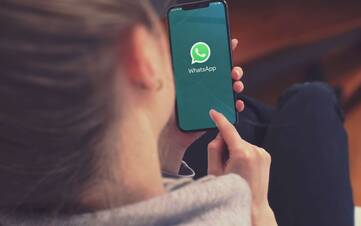 Person hält Smartphone mit geöffneter WhatsApp Anwendung in den Händen