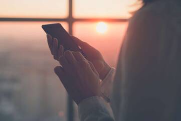 Person hält Smartphone in beiden Händen