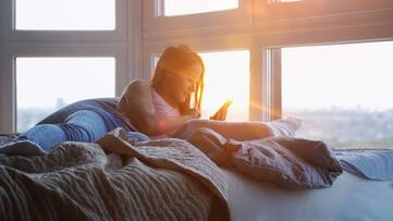Frau im Bett mit Smartphone
