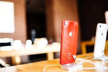 2 iPhones stehen angeschlossen auf einerm Holztisch