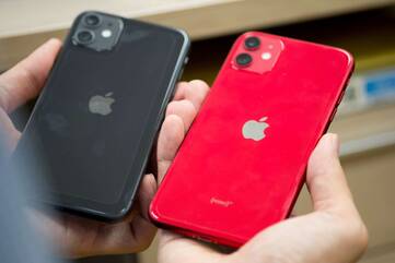 Ein rotes und ein schwarzes iPhone werden nebeneinander gehalten