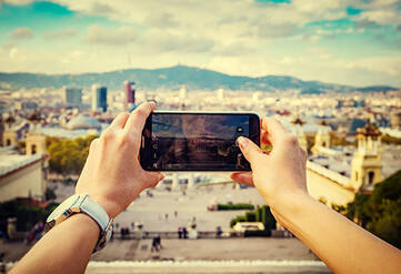Person macht mit einem Handy ein Foto von einer Stadt