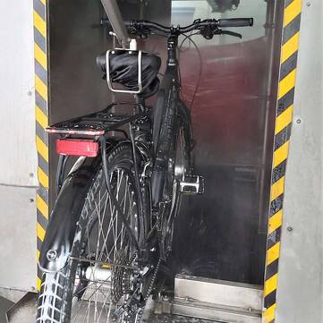 Das Fahrrad wird in die Waschstraße transportiert.
