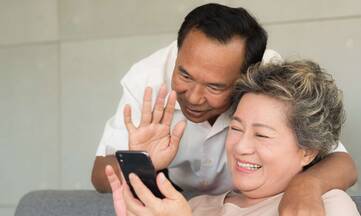 Zwei Personen lächeln in eine Smartphone Kamera