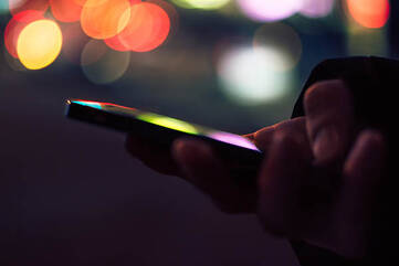 Smartphone in männlichen Händen bei Nacht