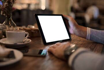 Person sitz im Café am iPad