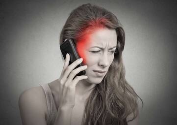 Telefonierende Frau mit Kopfschmerzen