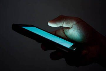 Smartphone liegt in der Hand im dunklen Raum