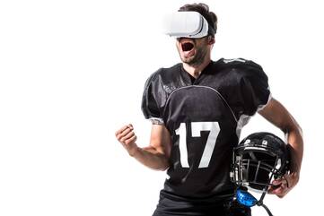 Person trägt eine VR-Brille und hat einen Football Helm in der Hand
