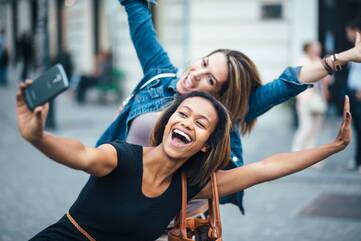 Zwei Frauen machen ein Selfie in der Innenstadt