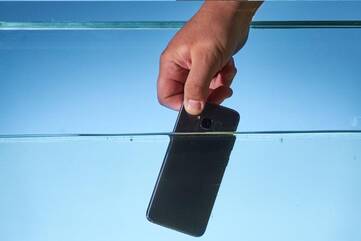 Smartphone wird ins Wasser gehalten
