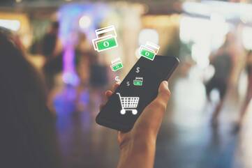 Smartphone und Grafiken wie Einkaufswagen und Geldscheine