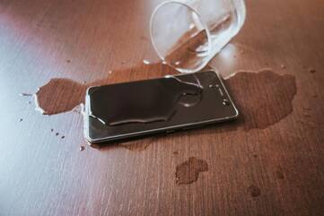 Wasserglas ausgelaufen über Handy