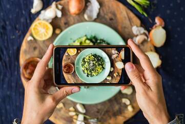 Person fotografiert mit Smartphone Essen