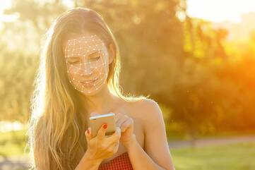 Frau benutzt Gesichtserkennung mit Handy