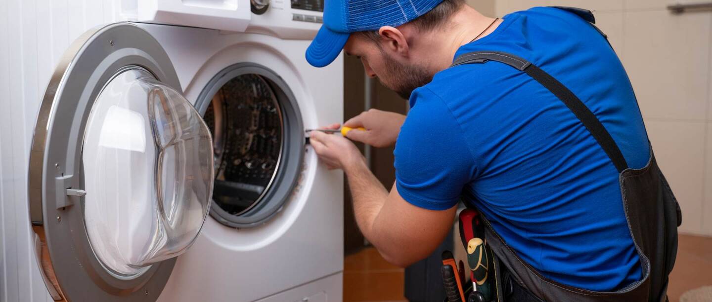 Eine Person repariert eine Waschmaschine