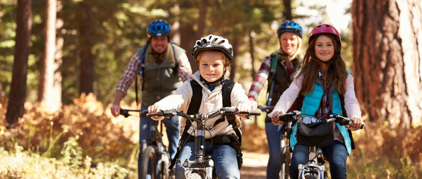 Familie fährt Fahrrad im Herbstwald