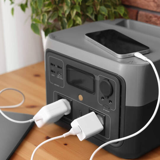 Eine Powerstation steht auf einem Tisch und lädt gerade ein Handy auf.