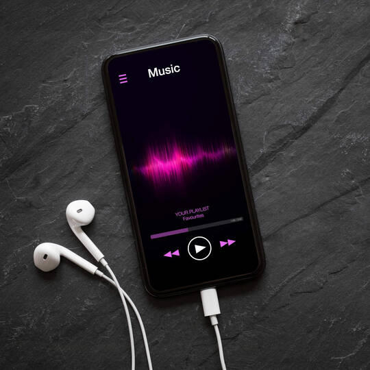 Auf einem Smartphone läuft ein Song in einem Streamingdienst.