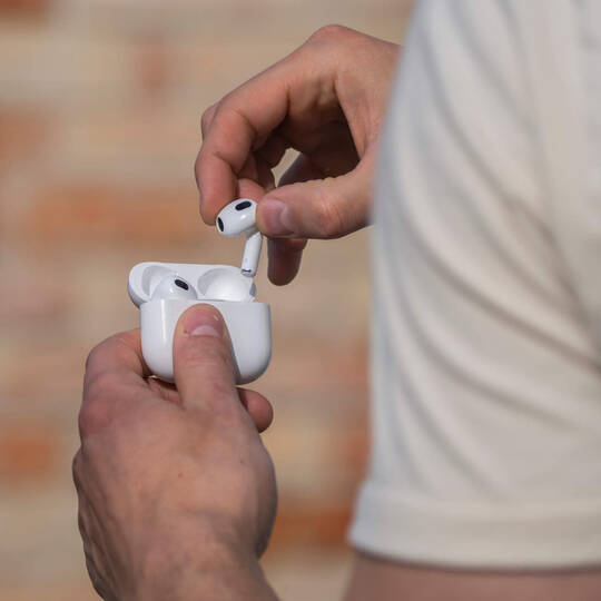 Ein Mann öffnet das Ladecase seiner Kopfhörer.