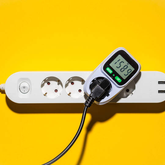Ein Energiekostenmessgerät steckt in einer Mehrfachsteckerleiste.