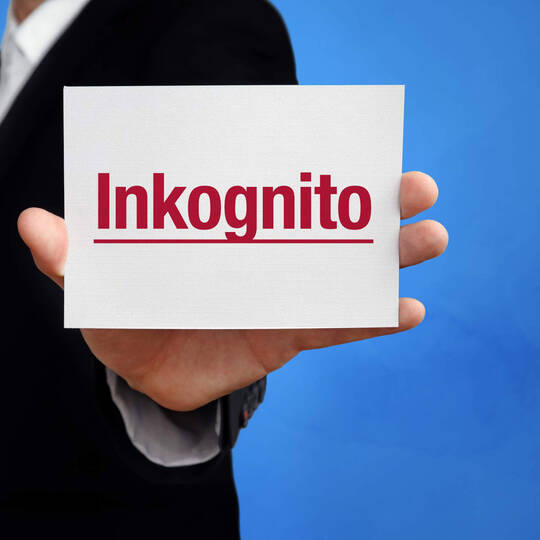 Mann hält Zettel mit Inkognito in der Hand