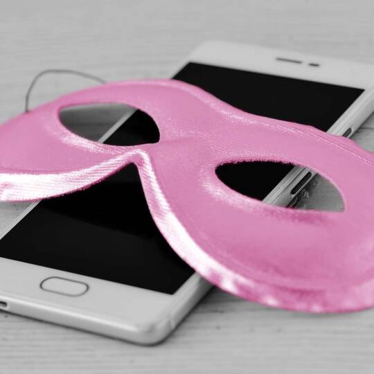 Pinke Maske liegt über einem Smartphone