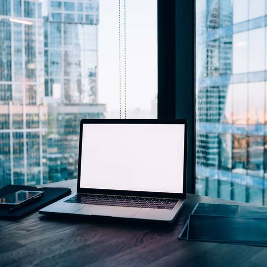 Arbeitsplatz mit MacBook vor Hochhäuser-Aussicht