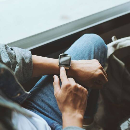 A person with a smartwatch on their wrist operates it