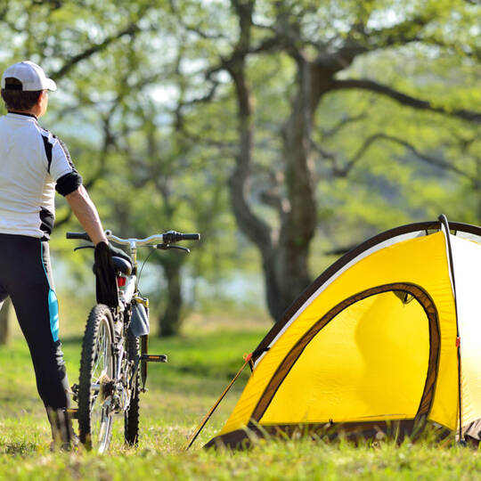 Ein Mann mit seinem Fahrrad und Zelt