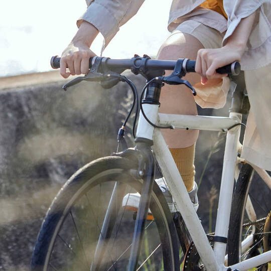 Frau mit kurzer Hose fährt auf einem weissen Fahrrad.