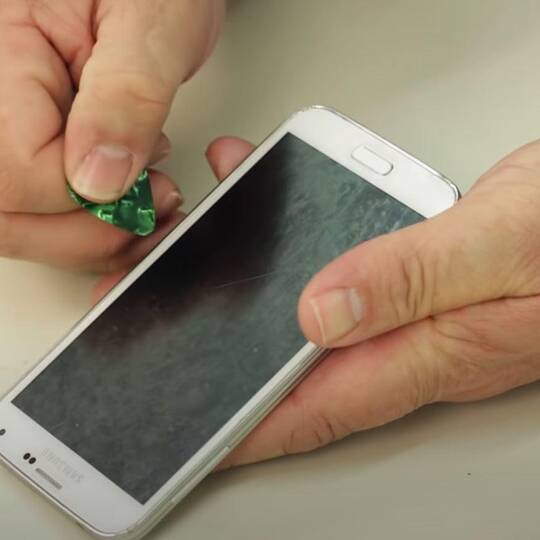 Zwei Hände halten ein Samsung Galaxy S5 und tauschen das Display aus