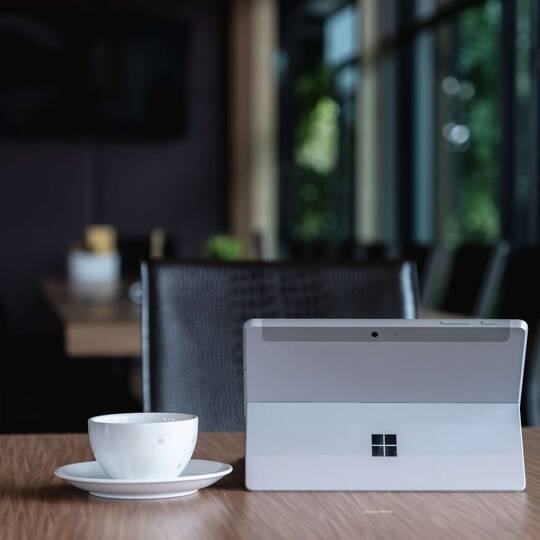 Windows Gerät steht auf Tisch vor leerem Stuhl