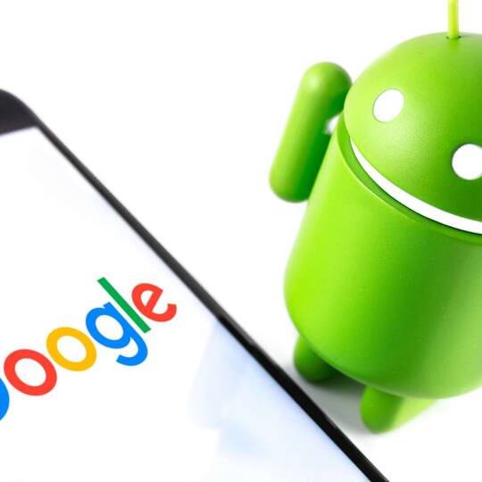 Android Maskott neben einem Smartphone