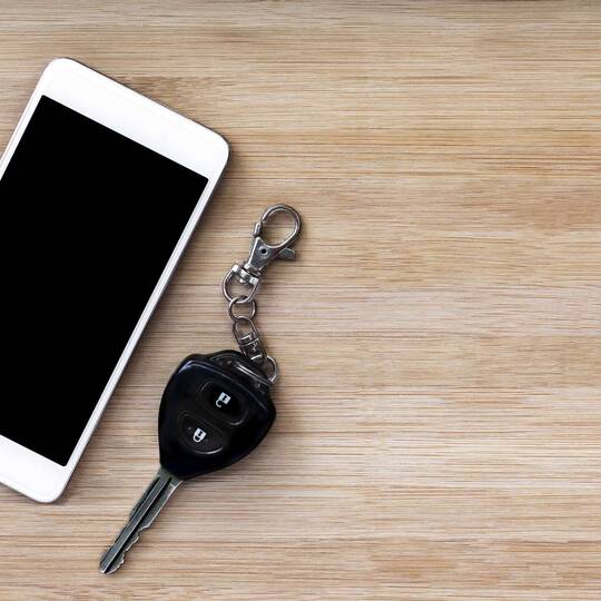 Smartphone und Autoschlüssel liegen nebeneinander