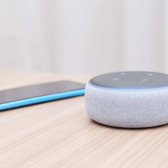 Alexa Echo Dot der dritten Generation und Smartphone auf einem Tisch