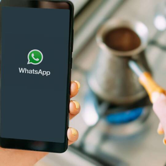 Person hält Smartphone mit WhatsApp Logo
