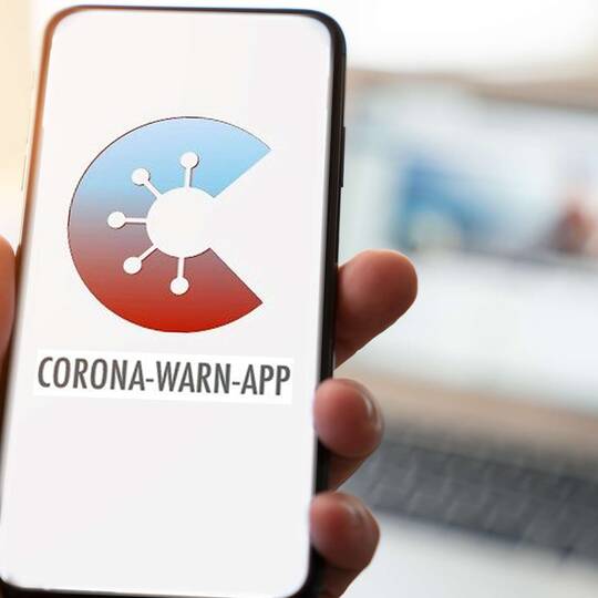 Hand hält Smartphone mit Corona App