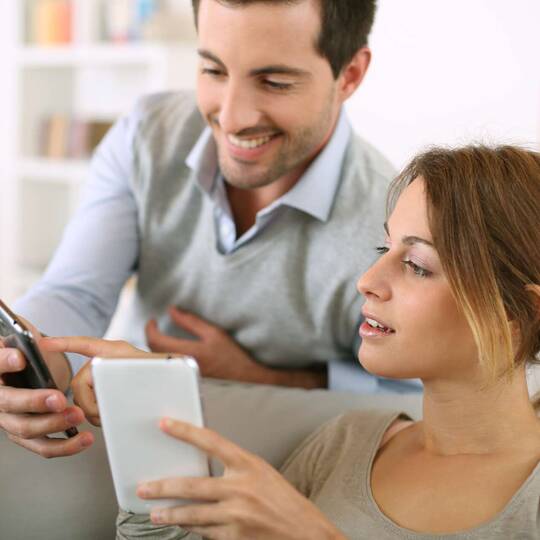 Paar schaut gemeinsam auf Smartphone Display