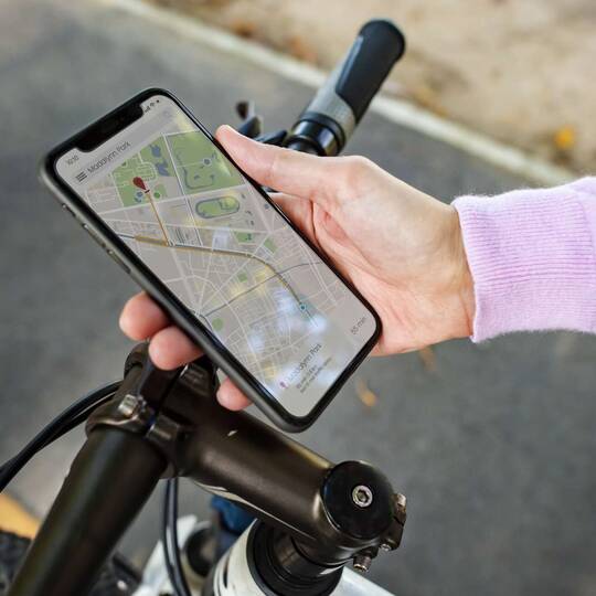 Ein Smartphone wird am Lenrad eines Fahrrads befestigt. 