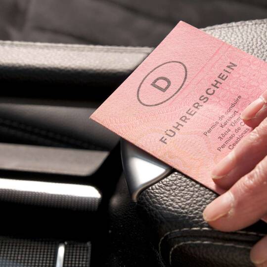 Hand hält Führerschein in Auto