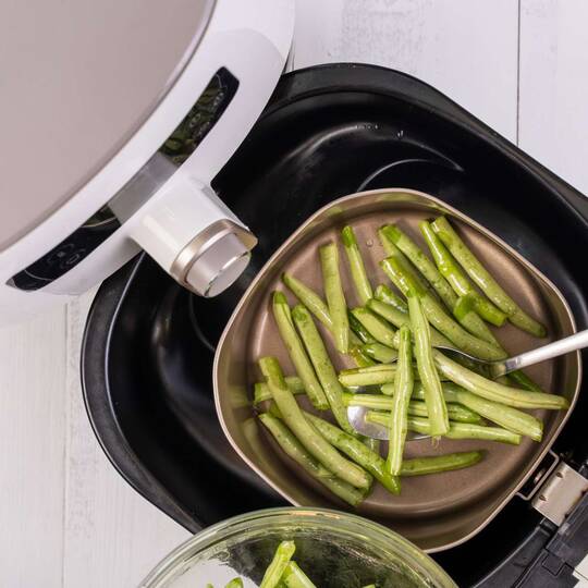 In einer Heißluftfritteuse wird Gemüse zubereitet.
