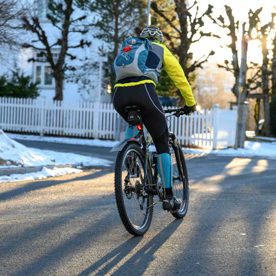 Fahrradfahrer fährt im Winter auf Straße