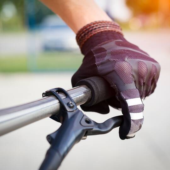 Behandschuhte Hand am Fahrradlenker