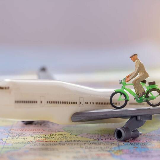 Ein Spielzeug-Fahrrad fährt auf dem Tragflügel eines Spielzeug-Flugzeugs.