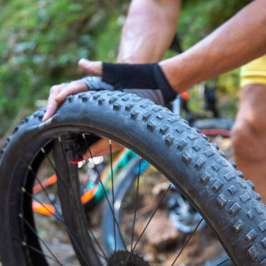 Mann prüft Druck von Fahrradschlauch mit Händen