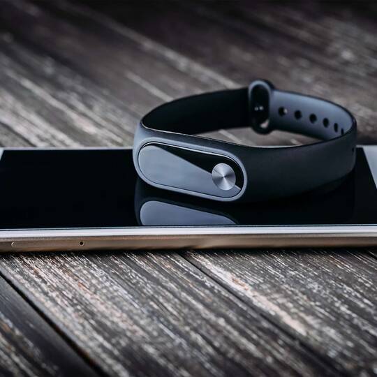 Fitness-Tracker liegt auf einem Smartphone