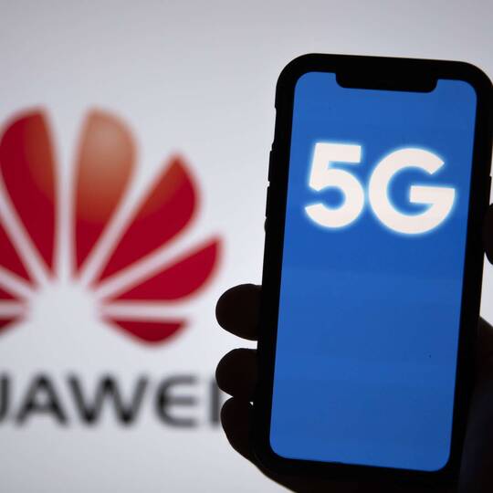 Smartphone mit 5G Anzeige vor Huawei Hintergrund