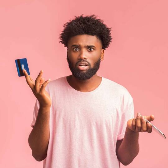 Mann hält Kreditkarte und Handy