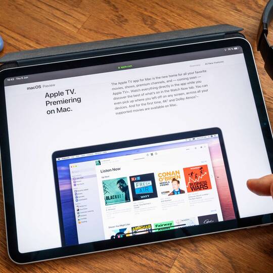Person scrollt auf ihrem iPad durch einen Apple TV Artikel